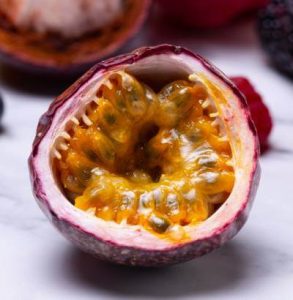 Passion fruit biologico siciliano tagliato a metà con polpa dorata e semi