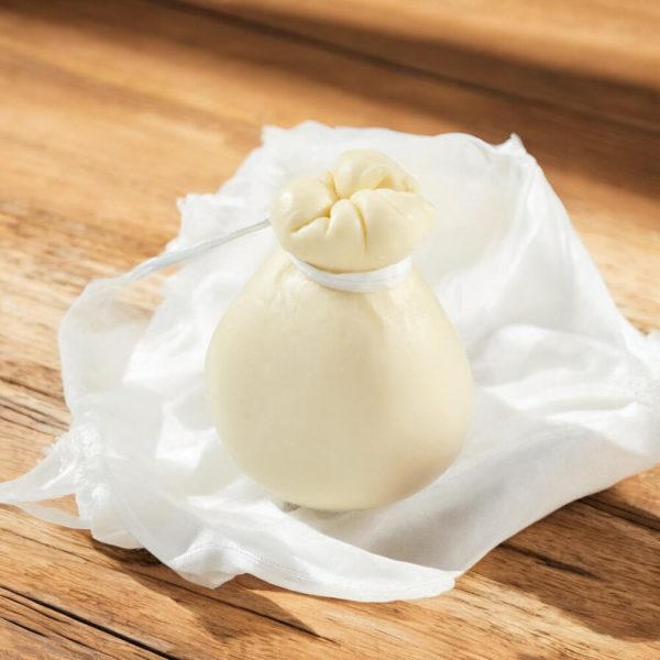 Ein frischer, weißer Provola Käse in Birnenform mit weißer Schnur gebunden.